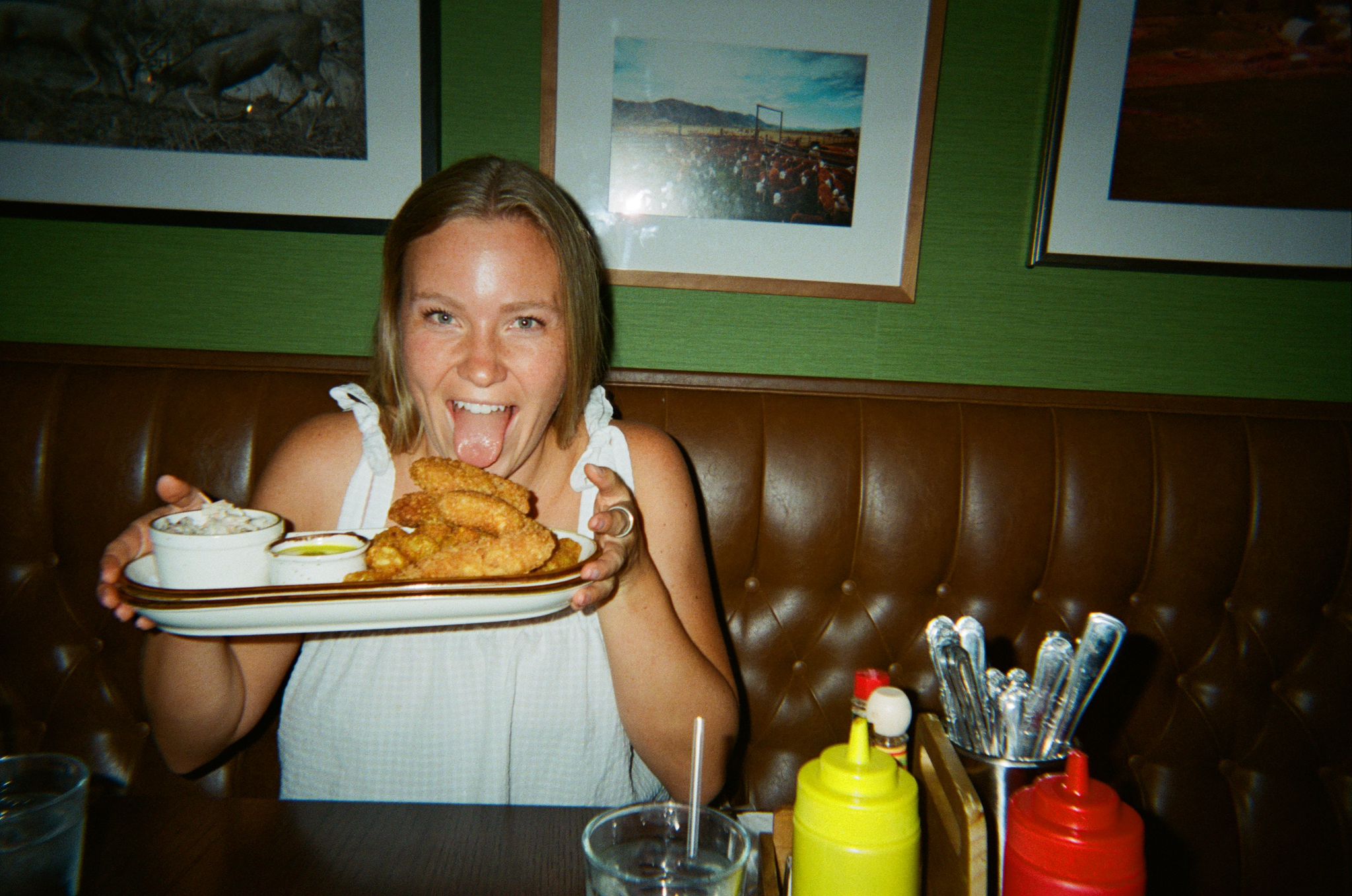 Aurelien in a restaurant booth, holding a platter of fried food